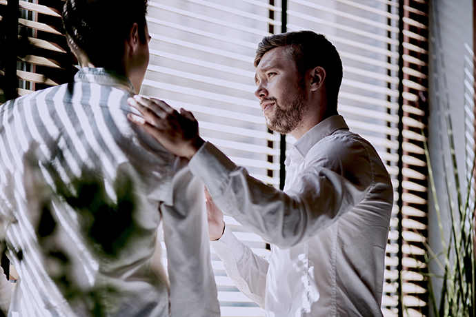 Man consoling a coworker at work