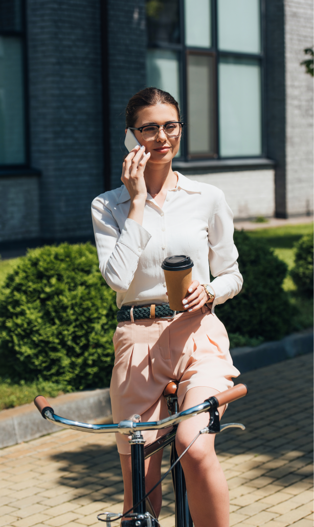 Mujer hablando por teléfono con un café en la mano.