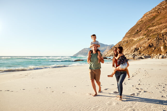 familia con niños caminando en la playa