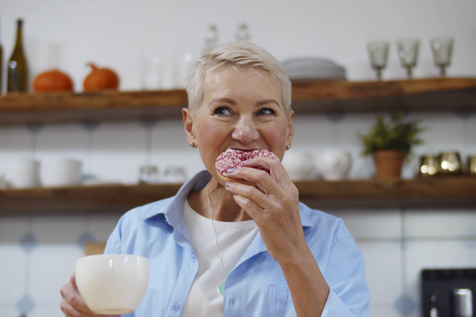 Mujer mayor comiendo alimentos ricos en azúcar