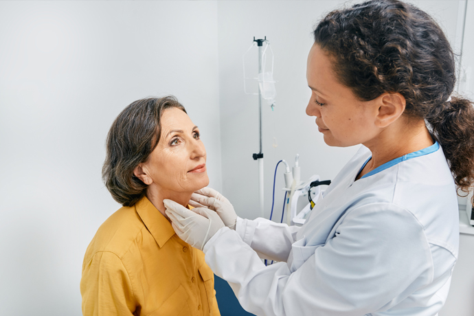 Doctor palpando al paciente, revisando la tiroides