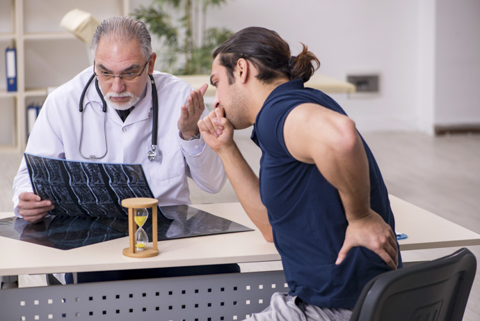 Hombre en consulta médica recibiendo el diagnóstico por el dolor en el costado izquierdo.