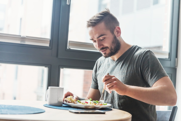 Hombre comiendo un plato de vegetales