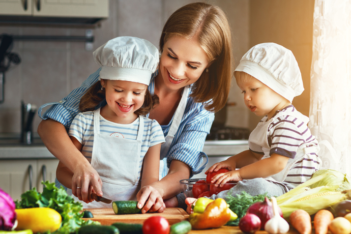 Mamá preeparando comida con su dos hijos