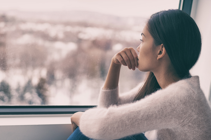 Mujer pensativa mirando por la ventana del tren