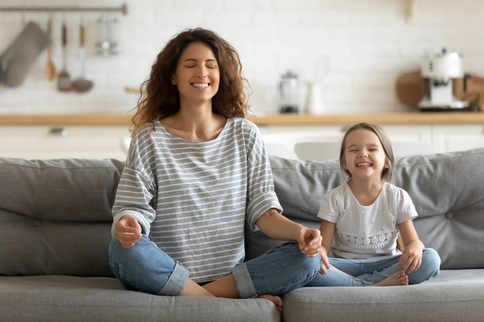 Madre con hija pequeña haciendo un ejercicio de relajación