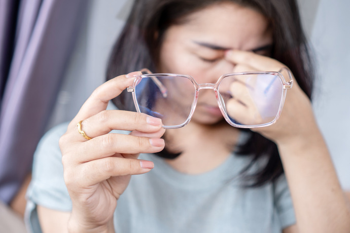 Mujer se quita las gafas molesta por la visión doble repentina