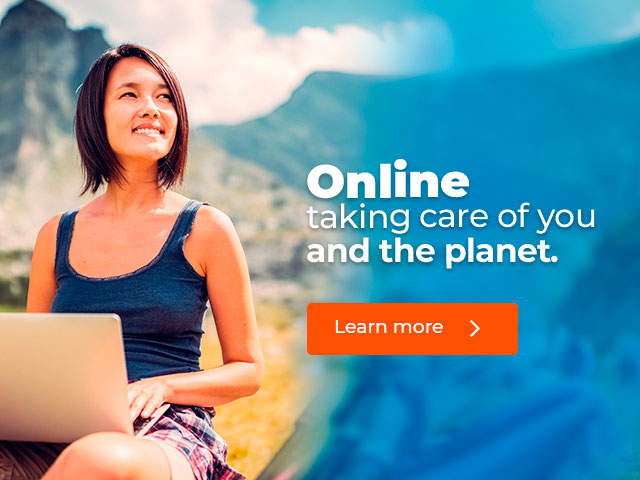 Woman with laptop smiling and looking towards the horizon.