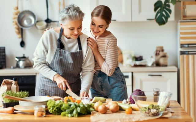 Mujer mayor con niña preparando comida saludable en la cocina