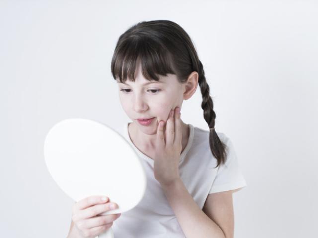 Niña detectando los signos de la pubertad precoz.