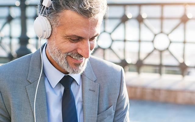 Banner contexto, señor con sus auriculares puestos sonriendo