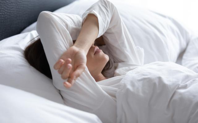 Mujer que tiene espasmos al dormir.