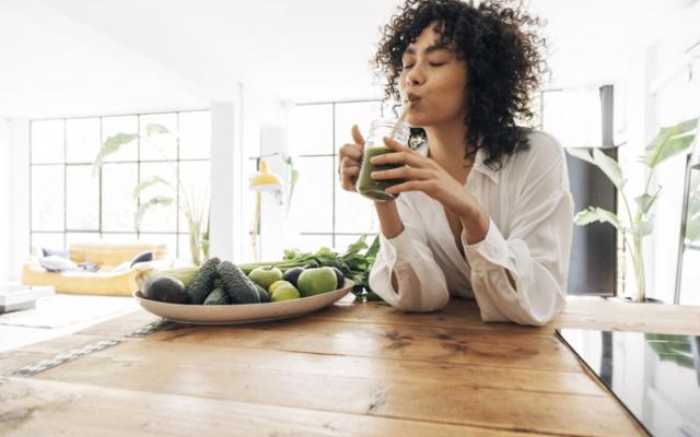 Mujer bebe jugo para bajar el azúcar