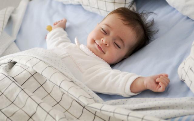 Bebé durmiendo cómodo en una cama