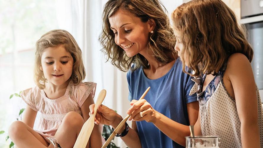 Madre cocinando con sus dos hijas