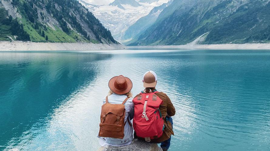 Dos personas sentadas frente a un lago.