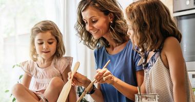 Madre cocinando con sus dos hijas