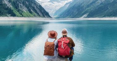 Dos personas sentadas frente a un lago