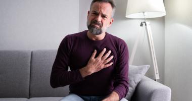 Hombre quejándose de dolor por no saber cómo bajar el colesterol de forma natural.