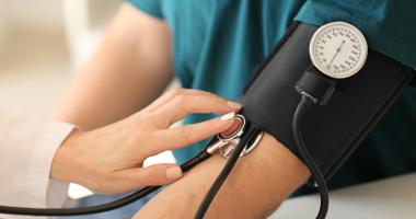 médico midiendo presión sanguínea