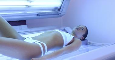 Mujer con adicción al sol en cama de bronceado