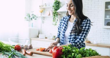 Mujer prepara comida con alimentos anticancerígenos
