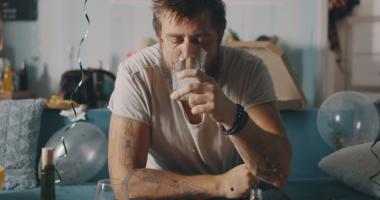 Hombre con resaca y deshidratación por alcohol