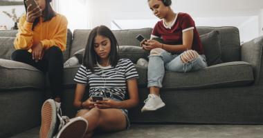 Grupo de adolescentes usando teléfono para ver memes