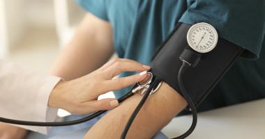 Paciente midiendo su presión arterial y pulso para comprobar sus valores en la tabla de presión arterial.
